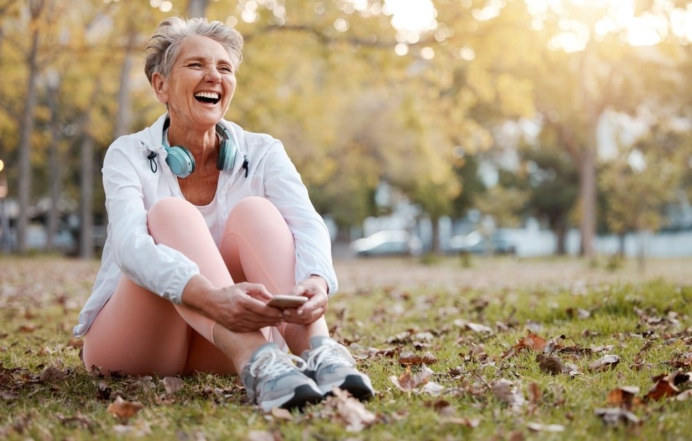 Senior woman sitting and resing after workout in park - Why Fascial Stretch Therapy is Essential for a Healthy Aging Process