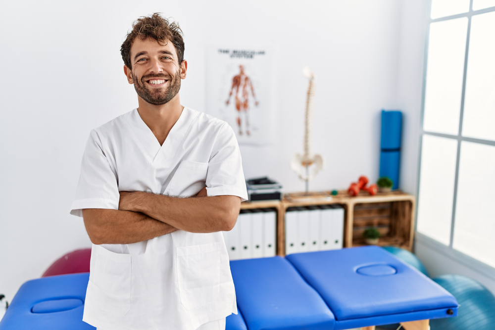 young physiotherapist man smiling - Top 5 Myths About Fascial Stretch Therapy Debunked