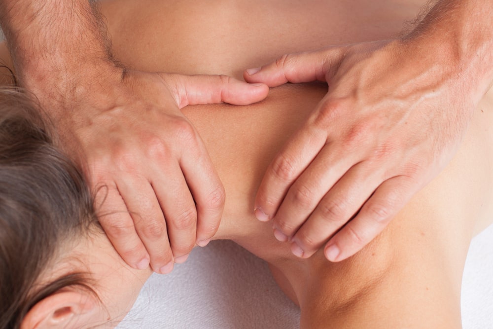 a specialist massaging a woman for Spinal Erector Discomfort