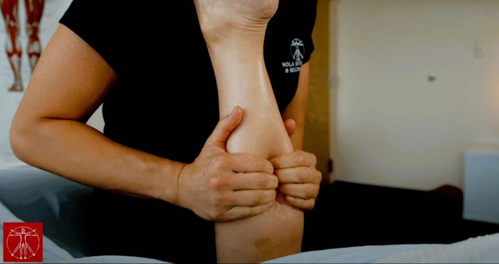 NOLA Stretch therapist providing Fascial Stretch Therapy to a young woman's lower leg, enhancing mobility and health.