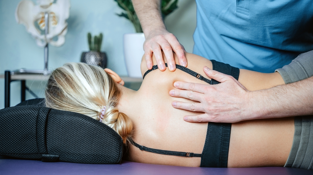 Fascial Stretch Therapy practitioner alleviating scapular or rhomboid muscle pain with hands-on techniques