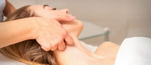 Beautician making lymphatic drainage face massage - massage therapist in metairie
